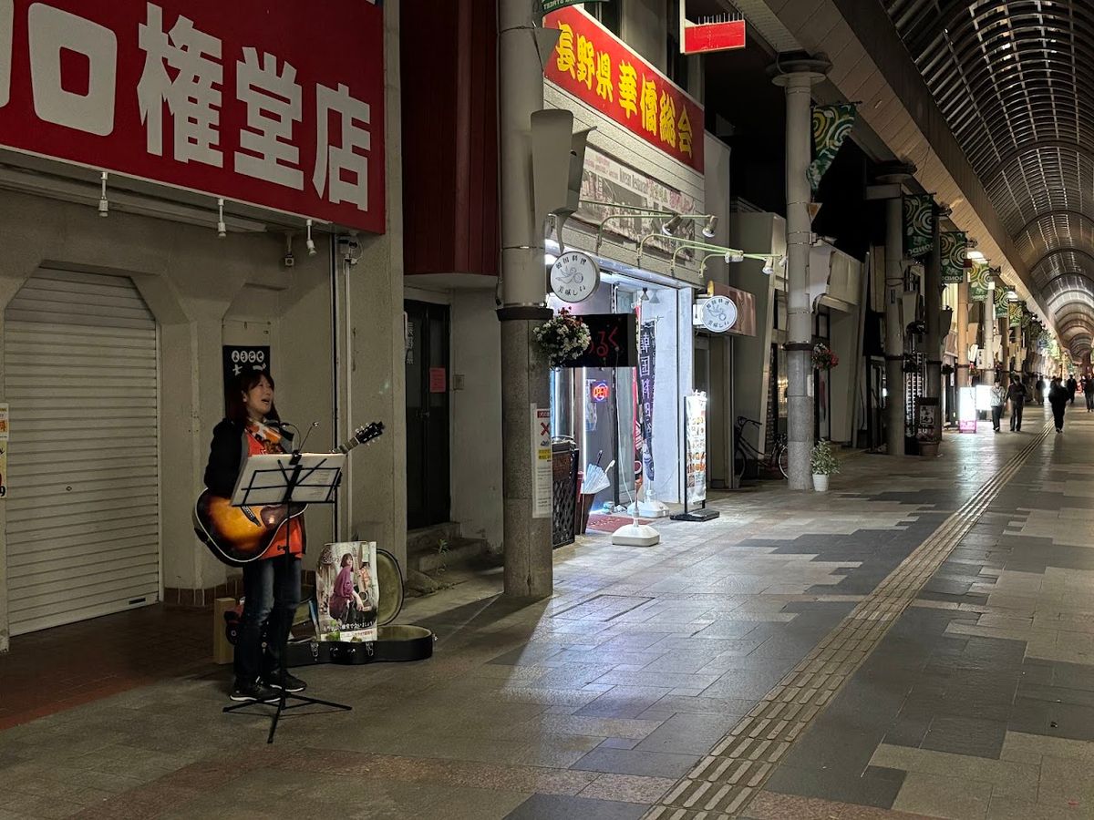 夜の権堂アーケードで路上ライブをする蓮香亜衣